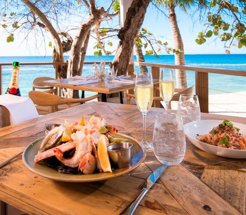 Plato de mariscos frescos y copas de champagne en un restaurante de playa de lujo en República Dominicana.