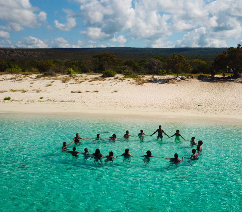 Grupo de amigos disfrutando de las aguas poco profundas y cristalinas de Bahía de las Águilas.