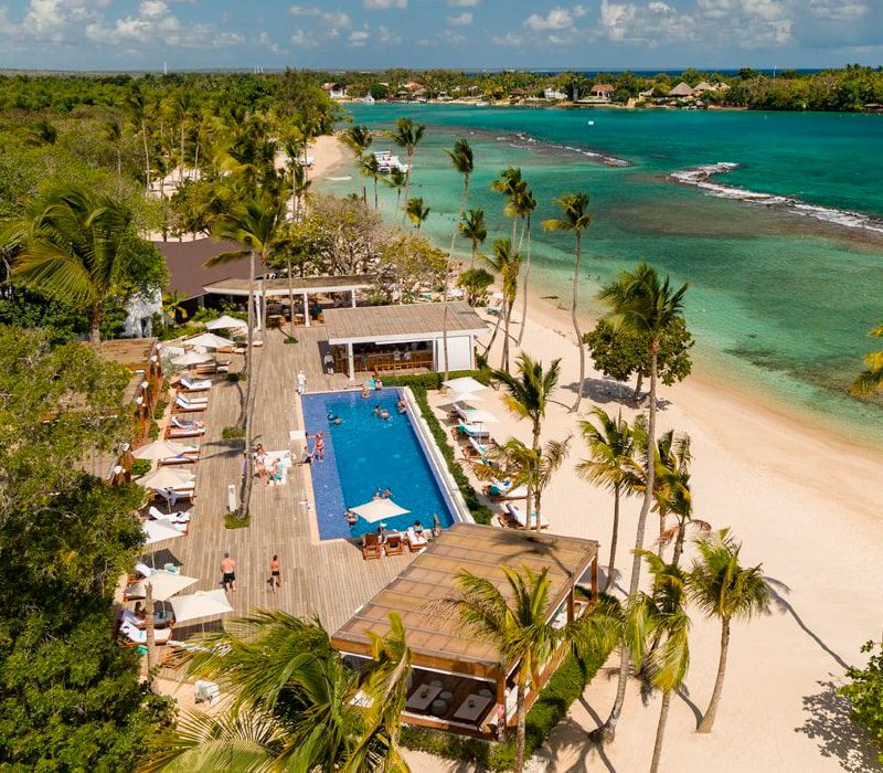 Vista aérea del exclusivo Minitas Beach Club en Casa de Campo, mostrando la piscina infinity frente al mar y la zona de tumbonas.
