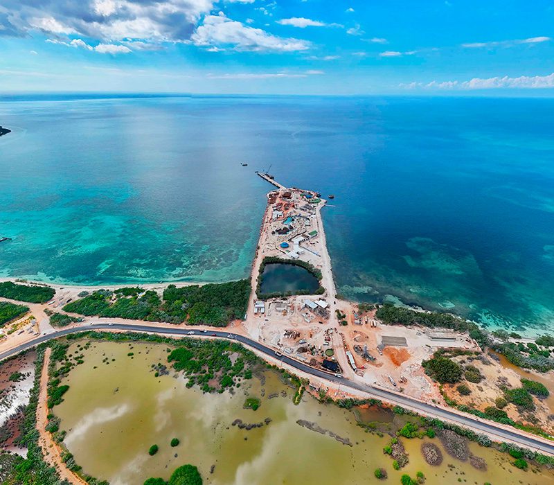 Vista aérea de la construcción del nuevo Puerto de Cabo Rojo en Pedernales, mostrando el muelle de cruceros y el desarrollo hotelero.